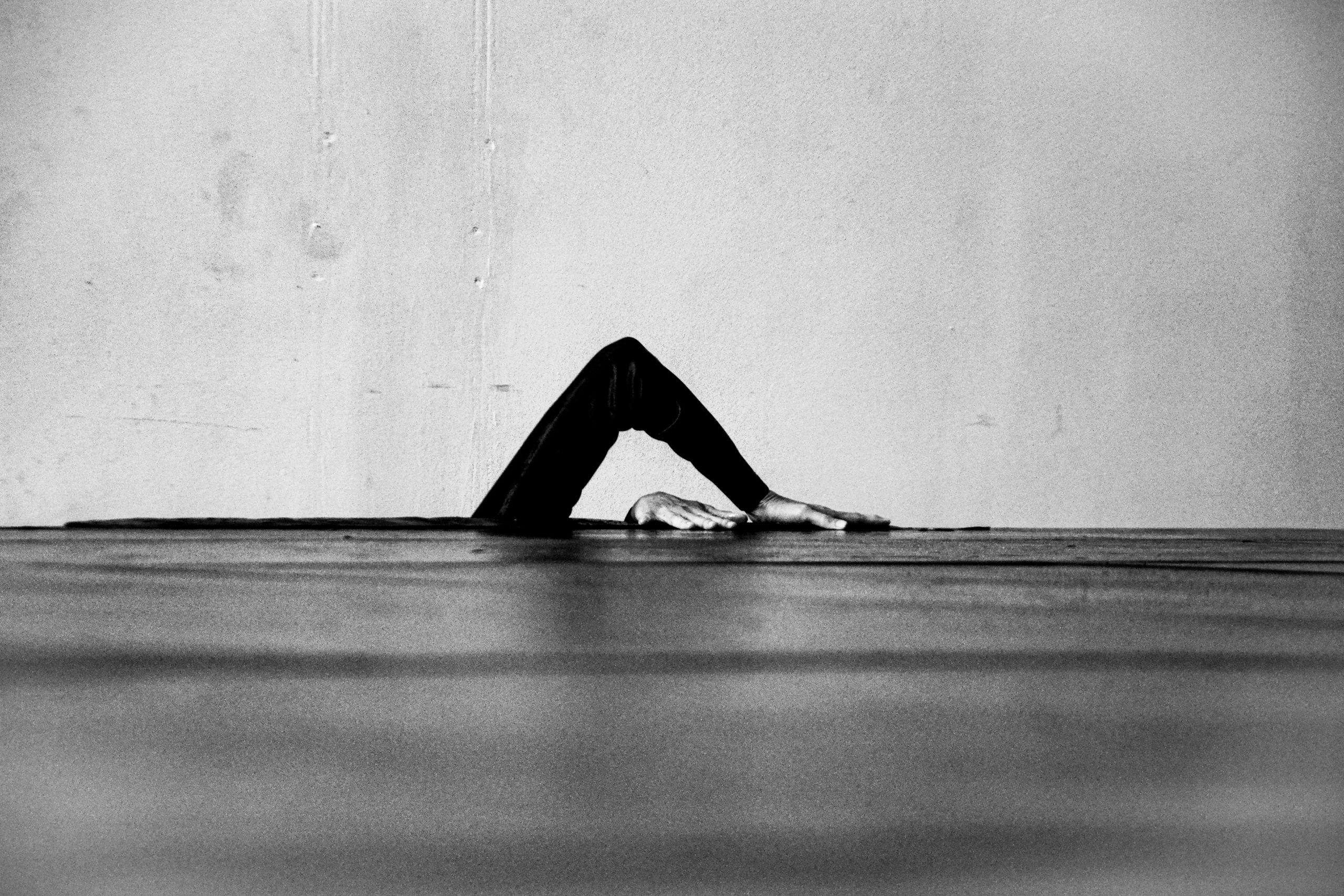 Photographie en noir et blanc. Mains d'un danseuse formant une forme géométrique au centre de l'image. 